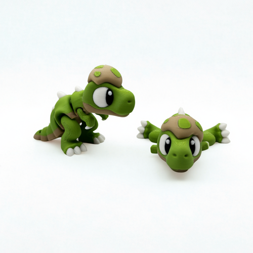 Two green toy t-rexes with brown shells on a white background